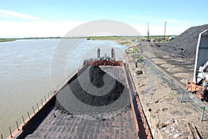 Barge with coal at river port Kolyma