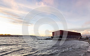 Barge container ship collided on a rocky coast during wind storm.