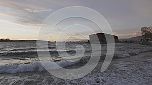 Barge container ship collided on a rocky coast during wind storm. Sunset Sky.