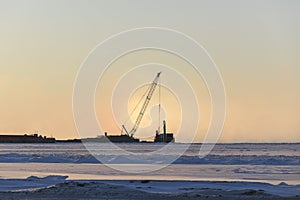 Barge with crane. Dredger working at sea. Sunset in Arctic sea. Construction Marine offshore works. Dam building, crane, barge,