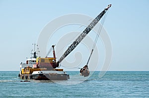 Barge dredging a harbor photo