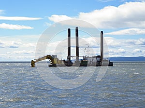 Barge with excavator. Excavator on the barge. Special vessel with a ladle and piles for anchoring on the ground