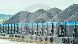 Barge full of black coal cruising on Mahakam River, Borneo, Indonesia.