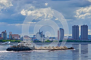 A barge loaded with building materials moves along the Amur River