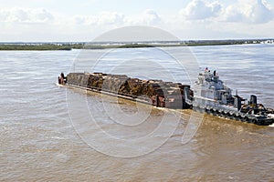 The barge transports timber along the river.