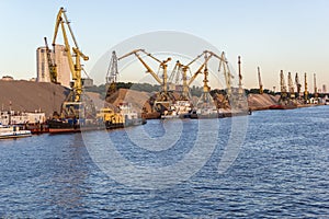 Barges and cranes in river port