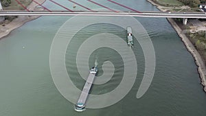 Barges Passing Under a Cable Stayed Suspension Bridge With Vehicles Crossing