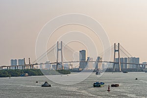 Barges and Phu My bridge over Song Sai Gon river, Ho Chi Minh City, Vietnam