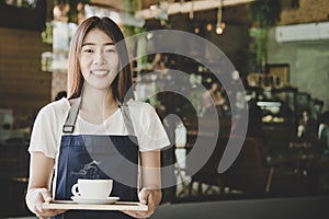 Barista asian women hands holding fresh coffee or latte art in white cup at coffee shop.