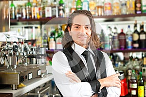 Barista or barman behind his bar