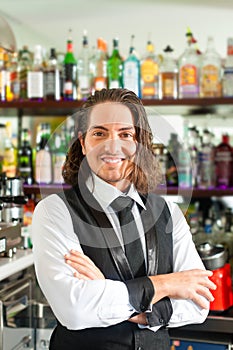 Barista or barman behind his bar