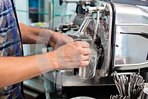 Barista in cafe or coffee bar preparing cappuccino