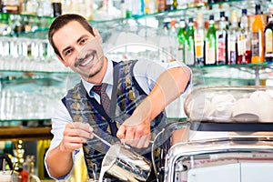 Barista in cafe pouring espresso shot in latte macchiato photo