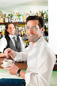Barista with client in his cafe or coffeeshop photo