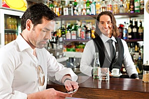 Barista with client in his cafe or coffeeshop photo