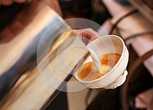 Barista in coffee bar preparing proper cappuccino pouring frothed milk into cup of coffee, making latte art, pattern