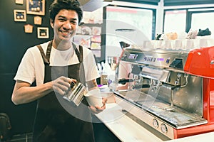 Barista in coffee shop holding mug or cup with vintage tone. Se