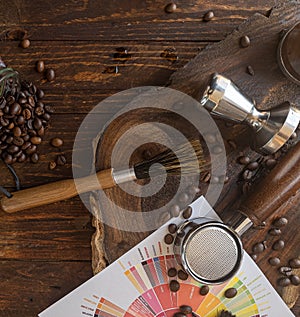 Barista coffee tools and roasted coffee beans on wooden board