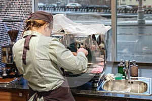 Barista girl prepares coffee in coffee machine