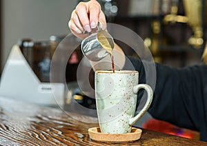 Barista girl prepares delicious aromatic coffee for coffee shop guests