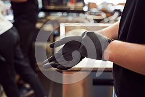 Barista hands in black gloves photo