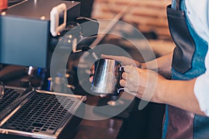 Barista heats milk steam for making lattes at coffee shop