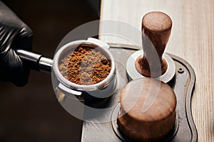 barista holding portafilter with grinded coffee