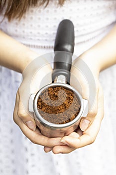 Barista holds a horn with ground coffee, top view