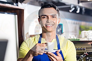 Barista in Indian cafe holding cup