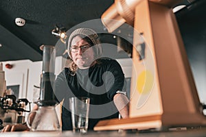 Barista makes aeropress coffee on wood bar in cafe. Alternative coffee brewing method