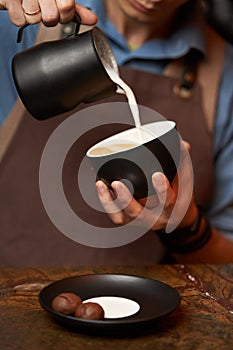 Barista making cappuccino, close-up. Bartender preparing latte art coffee.