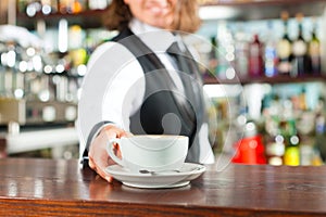 Barista making cappuccino in his coffeeshop