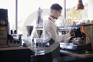 Barista Making Coffee In Delicatessen Using Machine photo