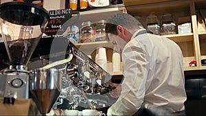 Barista is making coffee with steaming coffee machine in the shop or cafe bar
