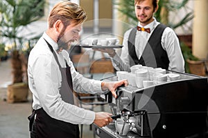 Barista making coffee with waiter