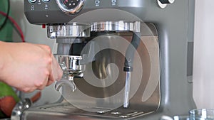 A barista making espresso with a coffee machine