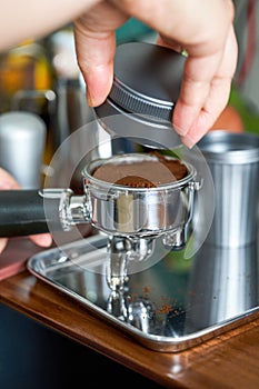 A barista making espresso with a coffee machine