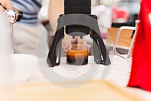 Barista making espresso coffee using Aeropress in cafe.