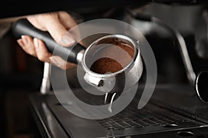 Barista making espresso using professional coffee machine, closeup