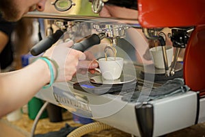 Barista making fresh aromatic coffee espresso, hands of bartender preparing coffee drink