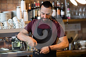 Barista man making espresso at bar or coffee shop