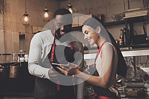 Barista man and woman looking at a tablet