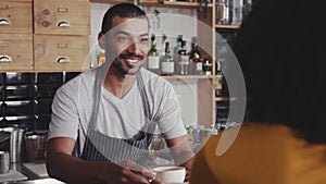 Barista offering coffee to the customer in cafe