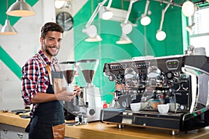 Barista offering a cup of coffee to camera in a cafe