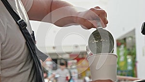 Barista poring hot milk in takeaway cup