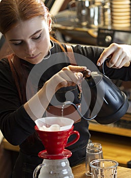 Barista pouring boiling water of manual drip brewer and make cof