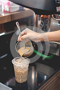Barista pouring coffee to glass for make iced coffee
