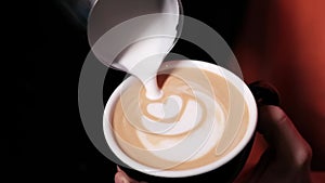 Barista pouring latte foam on coffee, espresso. creating a perfect latte art. dark colours, coffee house. slow motion