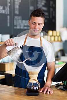 Barista pouring water into coffee filter