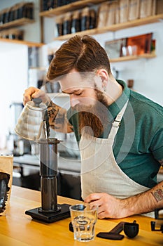 Barista pouring water on coffee ground with filter